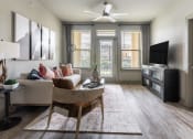 Thumbnail 6 of 23 - a living room with hardwood floors and a ceiling fan