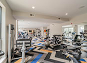 Thumbnail 13 of 35 - A gym with a variety of equipment including treadmills, weights, and exercise machines.