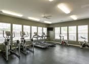 Thumbnail 8 of 15 - a gym with cardio equipment and windows