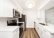 Thumbnail 28 of 42 - a renovated kitchen with white cabinets and stainless steel appliances