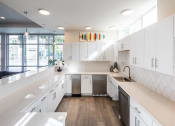 Thumbnail 34 of 45 - a large white kitchen with white cabinets and a sink