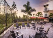 Thumbnail 32 of 45 - an outdoor patio with chairs and umbrellas at dusk