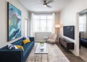 Thumbnail 13 of 45 - a living room with a blue couch and a television