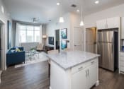 Thumbnail 18 of 45 - a kitchen and living room with a stainless steel refrigerator