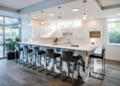 Thumbnail 10 of 45 - a kitchen with a bar and chairs