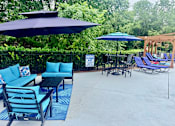 Thumbnail 10 of 47 - A patio with blue furniture and umbrellas.