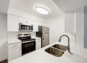 Thumbnail 26 of 42 - a kitchen with white cabinets and stainless steel appliances