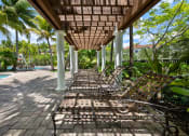 Thumbnail 7 of 44 - a row of wooden benches sitting under a covered porch