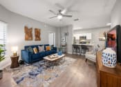 Thumbnail 10 of 67 - an open living room and kitchen with a blue couch and a ceiling fan
