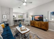 Thumbnail 9 of 67 - a living room with a blue couch and a tv