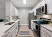 Thumbnail 13 of 67 - an open kitchen with white cabinets and stainless steel appliances and a microwave