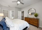Thumbnail 18 of 67 - a bedroom with a bed and a dresser and a ceiling fan