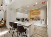 Thumbnail 36 of 67 - a kitchen with white cabinets and a marble counter top