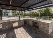 Thumbnail 30 of 45 - a patio with a kitchen and a pool