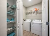 Thumbnail 24 of 67 - a laundry room with a washer and dryer and a closet with shelves