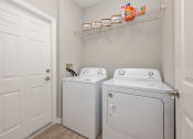 Thumbnail 26 of 67 - a washer and dryer in a laundry room with a white door