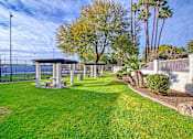 Thumbnail 25 of 28 - a grassy area with a pergola and trees in the background