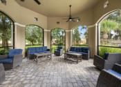 Thumbnail 61 of 67 - a covered patio with chairs and tables and large windows