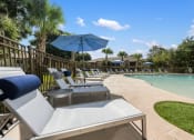 Thumbnail 58 of 67 - a pool with lounge chairs and umbrellas next to a pool