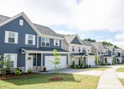Thumbnail 2 of 32 - A row of houses with a white garage door in the front.