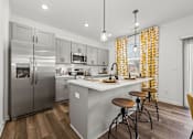Thumbnail 5 of 32 - A modern kitchen with a large island and stools.