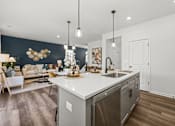 Thumbnail 4 of 32 - A modern kitchen with a large island and stainless steel appliances.