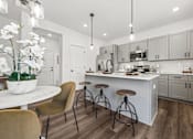 Thumbnail 7 of 32 - A modern kitchen with a bar area and a dining table.