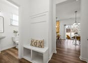 Thumbnail 22 of 32 - A white bathroom with a wooden floor and a white bench.