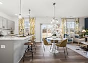 Thumbnail 9 of 32 - A modern kitchen with a dining area and a living room.
