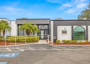 Thumbnail 27 of 29 - a building with palm trees and a parking lot