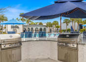 Thumbnail 26 of 29 - a resort style bar with barbecue grills and umbrellas