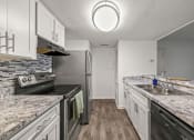 Thumbnail 2 of 29 - a kitchen with granite counter tops and stainless steel appliances