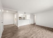 Thumbnail 4 of 29 - an empty living room and kitchen with wood flooring