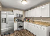 Thumbnail 1 of 29 - a kitchen with stainless steel appliances and white cabinets