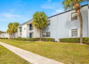 Thumbnail 28 of 29 - a white apartment building with palm trees in front of it