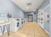 Thumbnail 17 of 29 - a laundry room with a row of washing machines