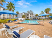 Thumbnail 20 of 29 - a swimming pool with lounge chairs and umbrellas