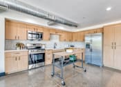 Thumbnail 29 of 40 - A kitchen with wooden cabinets and stainless steel appliances.