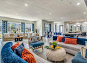 Thumbnail 8 of 40 - A living room with a blue velvet sofa and a woven coffee table.