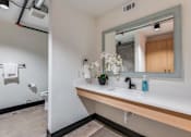 Thumbnail 22 of 40 - A bathroom with a white sink and a mirror.