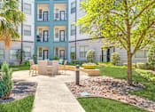 Thumbnail 6 of 40 - A modern apartment complex with a well-maintained courtyard.