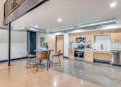 Thumbnail 18 of 40 - A modern kitchen with a dining table and chairs.