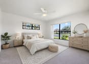 Thumbnail 2 of 48 - A bedroom with a large bed, a ceiling fan, and a window with a view of the outdoors.