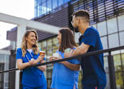 Thumbnail 44 of 45 - Three people in blue scrubs are standing on a balcony.
