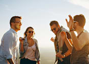 Thumbnail 19 of 19 - Four friends are standing together and enjoying the sunset.
