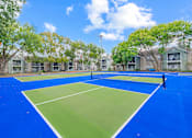 Thumbnail 45 of 51 - A tennis court with a blue surface and white lines.