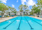 Thumbnail 30 of 51 - A swimming pool in front of a building with trees around.