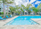 Thumbnail 29 of 51 - A swimming pool surrounded by trees and chairs with a 3 ft no diving sign.