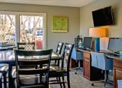 Thumbnail 8 of 22 - a dining room with a table and chairs and a desk with a computer