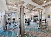 Thumbnail 11 of 26 - A gym with a variety of equipment including a squat rack, a bench press, and a rowing machine.